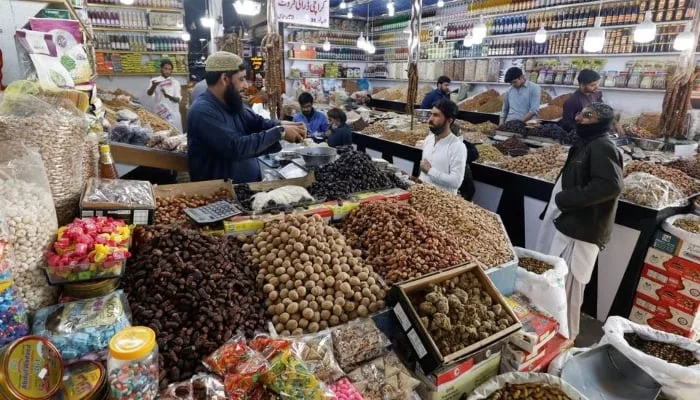 People buy dry fruits at a market in Karachi, Pakistan